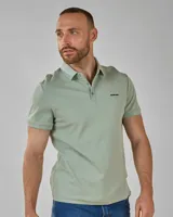 Chomba lisa de piqué color verde claro, con cuello clásico y tapeta de dos botones.