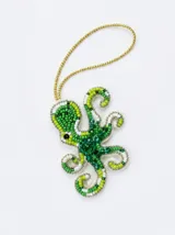 Llavero decorativo con forma de pulpo, bordado artesanalmente con cuentas de cristal y mostacillas en tonos verdes y blancos. Incluye cordón dorado para colgar.