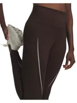 Calza deportiva de tiro alto color marrón, con paneles acanalados y detalles de líneas reflectantes en los laterales. Confeccionada en tejido de doble punto con interior cepillado para mayor calidez.