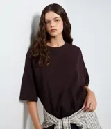 Remera de corte oversize color marrón oscuro, de cuello redondo y manga corta, confeccionada en mezcla de algodón y poliéster.