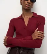 Blusa de manga larga con textura acanalada, cuello polo y escote en V. Confeccionada en tejido de viscosa y poliamida, presenta un corte regular que se ajusta de forma anatómica al cuerpo.