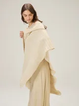 Chal tejido de punto color beige con acabado metalizado sutil, diseño ligero y caída fluida.