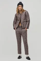 Pantalón de corte jogger con cintura elástica y cordón ajustable, confeccionado en jacquard con estampado damasco beige y negro.