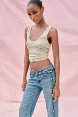 Collar largo de cordón negro con nudos, adornado con abalorios de diversos colores y formas, junto con charms metálicos dorados con forma de corazones y puntas. Su diseño versátil permite utilizarlo en múltiples posiciones.