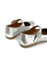 Zapato tipo Mary Jane plateado, 100% de cuero, con capellada, forro y plantilla de cuero. Ajuste con hebilla.