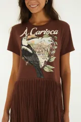 Vestido largo marrón de algodón con estampa frontal inspirada en Río de Janeiro que incluye un tucán y la inscripción 'Carioca', manga corta y falda larga adornada con múltiples niveles de flecos.