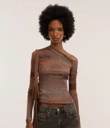 Blusa de tule color marrón con estampa manchada, cuello asimétrico, un hombro descubierto, mangas largas y encaje en uno de los laterales.