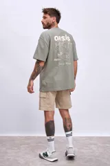 Remera de algodón color verde oliva, corte oversize, con cuello redondo y un pequeño logo bordado en el pecho.