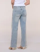 Jean wide leg de tiro medio y corte amplio, color azul claro. Presenta cintura con presillas, acceso frontal mediante cierre y botón metálico, y diseño de cinco bolsillos clásicos.