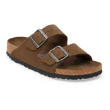 Sandalia Birkenstock modelo Arizona de dos correas ajustables con hebillas metálicas. Presenta una plantilla anatómica de corcho y suela de goma negra, confeccionada en gamuza color marrón oscuro.