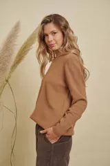 Buzo de punto color marrón, con cuello redondo y mangas largas, de corte holgado.