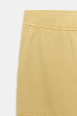 Pantalón de tiro medio color amarillo, con cintura elástica, bolsillos de plastrón en el delantero y pernera holgada que se estrecha hacia el tobillo. Cuenta con cierre frontal de cremallera y botón.