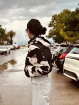 Campera puffer cropped color verde militar con mangas y capucha de polar estampado con cebra en blanco y negro.