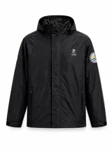 Campera impermeable de color negro con capucha ajustable, cierre frontal con solapa y bolsillos laterales. Presenta el logo de la marca Bagual bordado en el pecho y un parche circular con el sol de la bandera uruguaya en la manga.