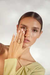 Anillo dorado con una perla blanca en el centro.