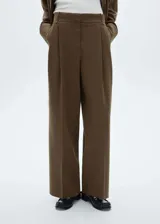 Pantalon de vestir de corte wide leg, color marrón con diseño de raya diplomática. Presenta tiro alto, detalle de pinzas en la parte frontal, trabillas para cinturón y bolsillos laterales.