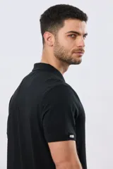 Remera polo de manga corta en color azul melange, con cuello camisero, cierre frontal de dos botones y pequeño bordado en el pecho.