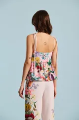 Blusa sin mangas de escote cuadrado, con tirantes finos ajustables mediante lazos en los hombros. Presenta un estampado floral colorido sobre base rosada y corte holgado.