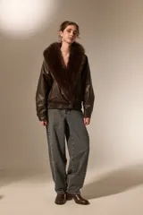 Campera de eco-cuero color marrón con cuello amplio de piel sintética al tono. Presenta un diseño de corte holgado, mangas largas y cierre frontal con botones.