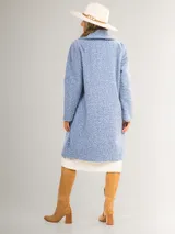 Tapado celeste de paño con doble botonadura, cuello solapa y bolsillos laterales.