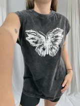 Remerón negro con estampa de mariposa blanca en el frente, sin mangas y corte holgado.