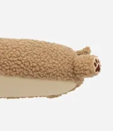 Pantufla cerrada de diseño divertido con forma de perro, confeccionada en tejido de poliéster tipo peluche color tostado, con detalles bordados de huellas en las patas.