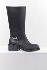 Bota de cuero negra con caña media, taco cuadrado y detalle de correa con pieza metálica plateada alrededor del tobillo.