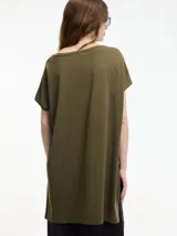 Remera blanca de algodón, corte amplio y largo irregular con tajos laterales.