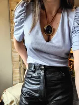 Blusa celeste de lurex con escote en V y mangas abullonadas cortas.