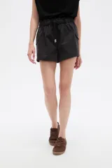 Short cargo negro de poliéster, con cintura elástica fruncida y cordón ajustable. Posee bolsillos laterales tipo cargo.