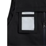 Chaleco acolchado negro con cierre frontal, cuello alto y múltiples bolsillos frontales con cierre y solapa. Diseño técnico con detalles en amarillo.