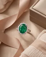 Anillo de plata con piedra central tallada en corte ovalado de color verde esmeralda, rodeada por un pavé de pequeñas circonias brillantes.