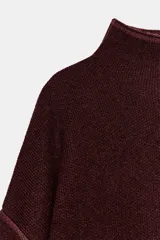 Jersey de punto color bordó con cuello subido, manga larga y diseño de corte holgado con costuras caídas en los hombros.