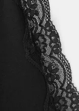 Top negro de algodón con diseño entallado, cuello halter y ribetes de encaje en los hombros y cuello. No incluye mangas.