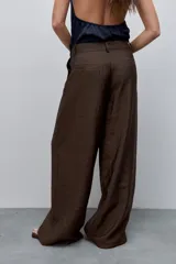 Pantalón wide leg de tiro alto, confeccionado en tela ligera de caída fluida y brillo sutil.