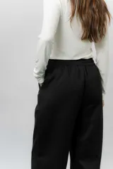 Pantalón deportivo de corte wide leg con caída relajada. Presenta cintura elastizada con cordón ajustable, bolsillos laterales y un interior frizado para mayor abrigo.