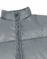 Campera puffer de nylon acolchada color beige, con cuello alto y cierre frontal. Presenta el logo de la marca Mistral estampado en el pecho.