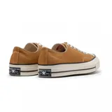 Championes Converse Chuck 70 color ocre, de caña baja y cordones blancos.