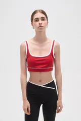 Top deportivo de poliamida color rojo con ribetes blancos en el escote y breteles. Diseño al cuerpo con elástico en la base.