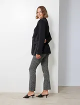 Blazer negro de satén con cuello con solapa, abertura con botón, bolsillos ojal simulados y solapa, manga larga y puño con botón.