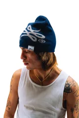 Gorro de lana tejido reversible, un lado azul marino y el otro gris, con diseño de moños en ambos lados.