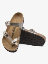 Sandalia Birkenstock modelo Mayari, color plateado metálico, con dos tiras ajustables con hebillas y una tira de dedo. La plantilla es anatómica de corcho-látex y el material superior es Birko-Flor.