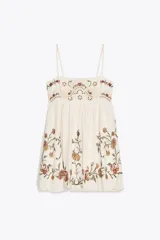Vestido corto color crudo con tirantes finos ajustables, escote recto y bordado floral a contraste.
