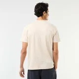 Remera de manga corta color beige, con cuello tunecino y cartera con botones frontales.