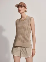 Musculosa de punto color beige con diseño calado y aberturas laterales.