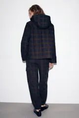 Pantalón cargo de tiro medio con estampado de cuadros, bolsillos laterales tipo cargo con solapa y bajo ajustable con cordones. Cuenta con cierre frontal de cremallera y botón.