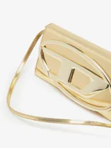 Cartera tipo sobre Diesel 1DR, color dorado con acabado metalizado y logo ovalado en relieve.