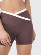 Calza biker color marrón con cintura en V y ribete blanco en los bordes.