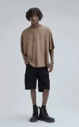 Remera de manga corta con calce extra oversize, color marrón chocolate con efecto gastado/deslavado. Presenta un corte con recortes horizontales en el frente y la espalda, y cuello redondo con terminación deshilachada.