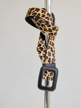 Cinto de cuero con estampado animal print de leopardo, con hebilla cuadrada de cuero negro y costuras a la vista.